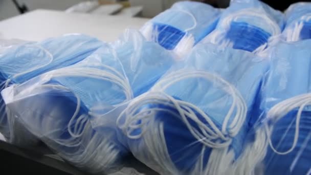 Montão de máscaras de proteção descartáveis azuis na mesa na loja — Vídeo de Stock