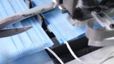 Makine elastik bantları koruyucu maskelere keser ve bağlar