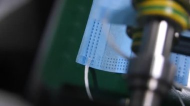 Makine, tek kullanımlık koruyucu maskeleri fabrikaya koyar.