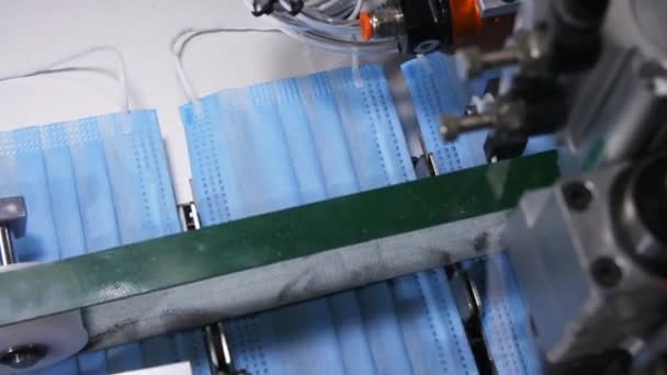 Maszyna prasuje niebieskie obszycia arkuszy tkanin masek jednorazowego użytku — Wideo stockowe