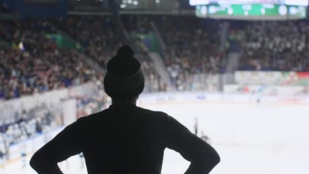 Человек в теплой шляпе смотрит хоккей с места зрителя — стоковое видео
