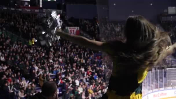 Cheerleader with shining pompoms dances on spectator places — Stock Video