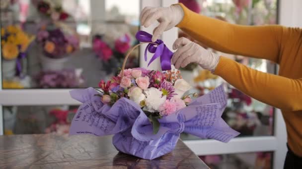 Florist justerar band på korg med vackra blommor — Stockvideo