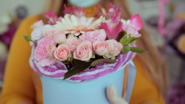 Movimiento a las flores suaves en la caja azul claro sostenida por la mujer — Vídeos de Stock