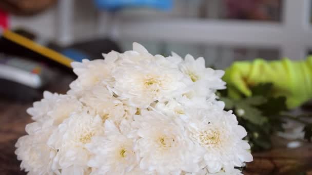 Florist tar vita krysantemum blommor från högen i butiken — Stockvideo