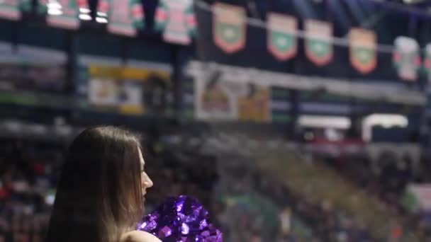 Дівчина з пурпуровими помпезними танцями підтримує хокеїстів — стокове відео