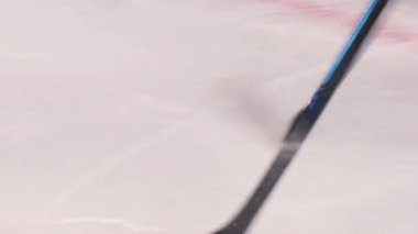 Hokey oyuncusu siyah diski rakip takım kapısına götürüyor.