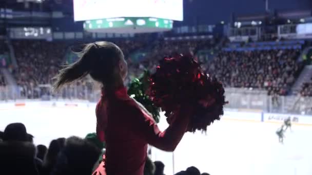 Chica con coleta baila con pompones para apoyar a los jugadores — Vídeos de Stock