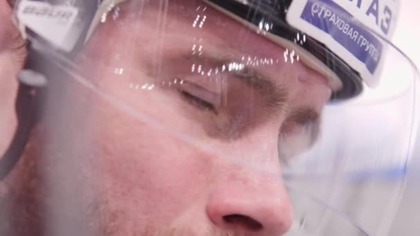 Young hockey player in helmet waits for sports game closeup — Stock Video