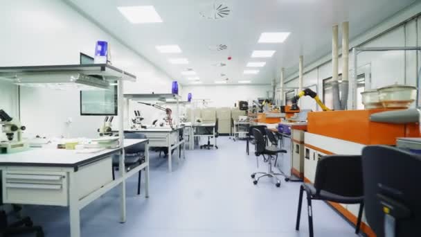 Rörelse längs laboratorium till kvinna tittar i mikroskop — Stockvideo