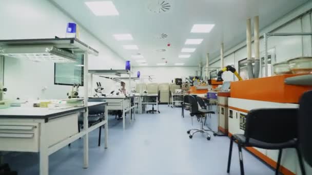 Movimento ao longo do laboratório de luz para o técnico que trabalha com microscópio — Vídeo de Stock
