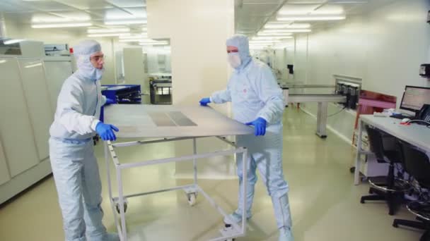 Υπάλληλοι θέσει ηλιακό πάνελ με κύτταρα στο τραπέζι κοντά σε μηχάνημα — Αρχείο Βίντεο