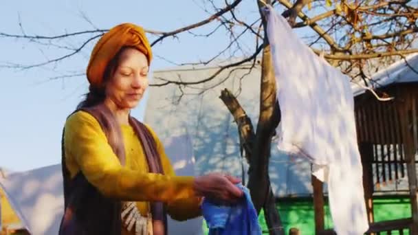 黄色の陽気な女性がロープにきれいな青のタオルを掛け — ストック動画