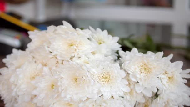 Florist arbetar med vita krysantemum vid bordet i butiken — Stockvideo