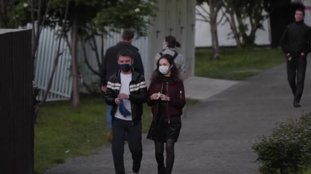 Vrouw en man met maskers op latex handschoenen in groen park — Stockvideo