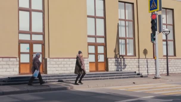 Nő meleg kabát és kalap fut át az utcán a város lassú — Stock videók