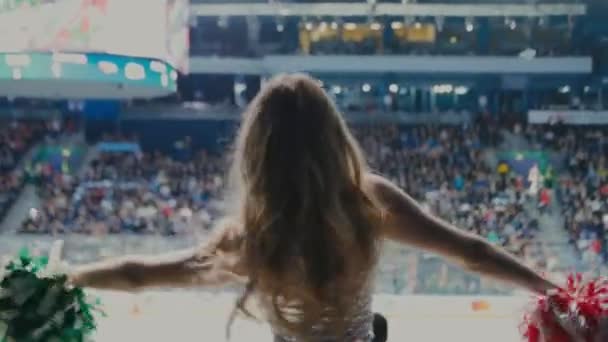 Cheerleader im silbernen Kleid tanzt in Zuschauernähe — Stockvideo