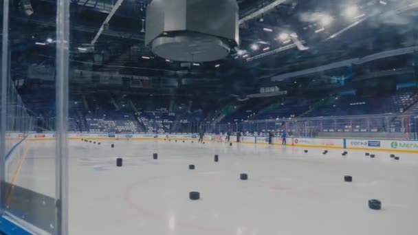 Les joueurs de hockey en survêtement s'entraînent sur une patinoire avec des pièces noires — Video