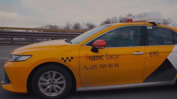 Yellow Yandex taxi cab with sign on roof drives along road — Stock Video
