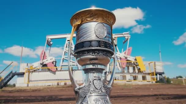 Sports cup with Yuri Gagarin against modern pump jacks — Stock Video