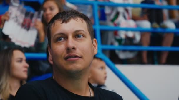 Joyful sports fan watches hockey game talking with friend — Stock Video