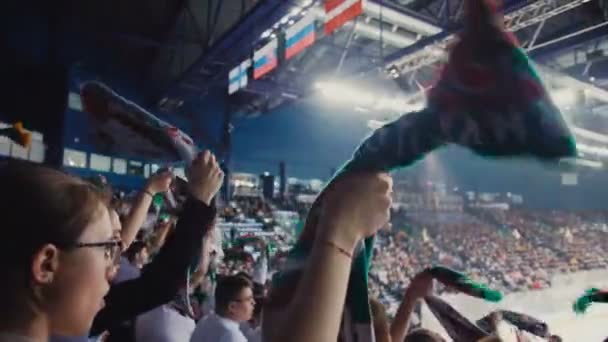 Šťastní lidé točit šály sledování hokejového utkání na stadionu — Stock video