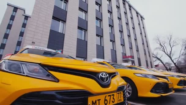 Řada taxíků Yandex s vlajkami a cedulemi v blízkosti budovy — Stock video