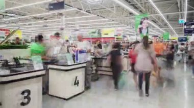 Süpermarkette kasiyer masalarının yanında alışveriş yapan müşteriler