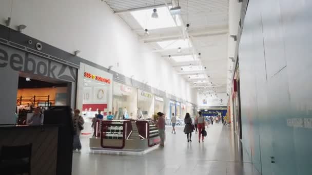 Movimiento a lo largo de largo pasillo entre diferentes tiendas en el centro comercial — Vídeos de Stock