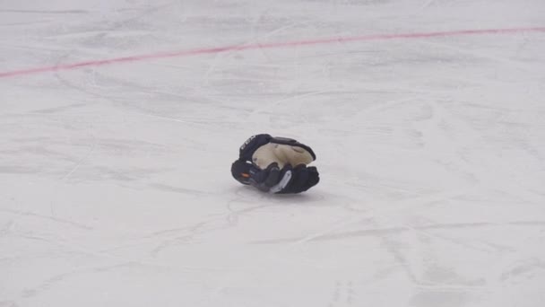 Хокеїст на ковзанах збирає рукавичку з льоду в грі. — стокове відео