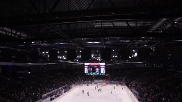 Les joueurs de hockey patinent sur la patinoire vue des lieux du spectateur — Video