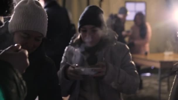 Γυναίκα με σακάκι και καπέλο τρώει φαγητό στο δρόμο το κρύο το χειμώνα — Αρχείο Βίντεο