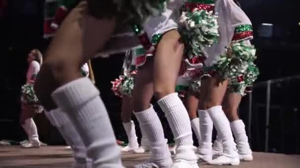 Cheerleaders i korta kostymer dansa med pompoms på stadion — Stockvideo