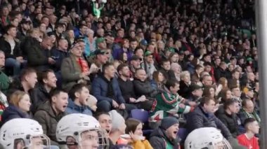 İnsanlar stadyumda hokey oyuncularını destekliyor.