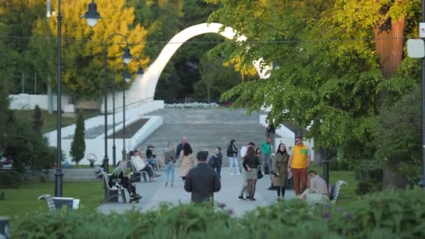 Широкая аллея возле ступенек с аркой и прогулочными людьми в парке — стоковое видео