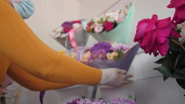 Жіночий флорист бере свіжий квітковий букет з дисплея — стокове відео