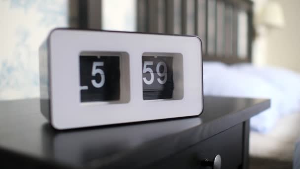 Flip clock in white case shows one minute to 6 pm on table — Stock Video