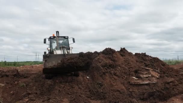 Excavadora entierra trinchera con tubo amarillo en la carcasa con la suciedad — Vídeos de Stock