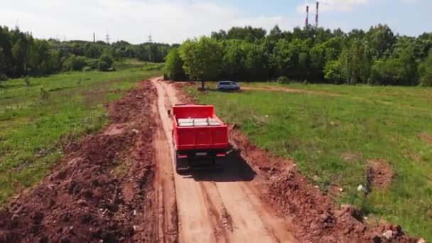 작업용 차량을 실은 팁 트럭은 시골 도로를 따라 운행 한다 — 비디오