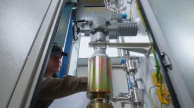 İşçi modern kontrol bloğunun tam teçhizatını inceliyor