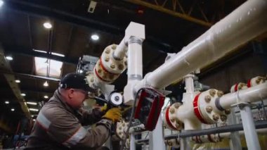 Olgun bir adam boru hattına kaynak yapıyor.