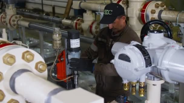 Trabajador maduro comprueba bloque de tubería terminada en taller — Vídeos de Stock