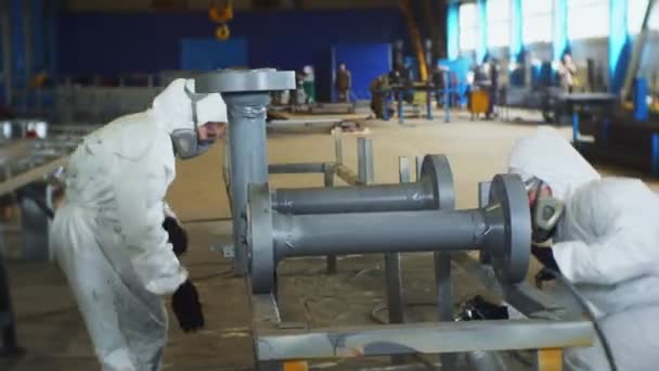 Trabajadores en trajes de protección pintan detalles del sistema de tuberías — Vídeos de Stock