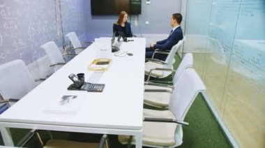 Konferans salonunda şirket yöneticisiyle röportaj yapan adam.