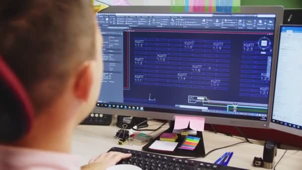 Инженер работает с чертежами на компьютере за столом в офисе — стоковое видео