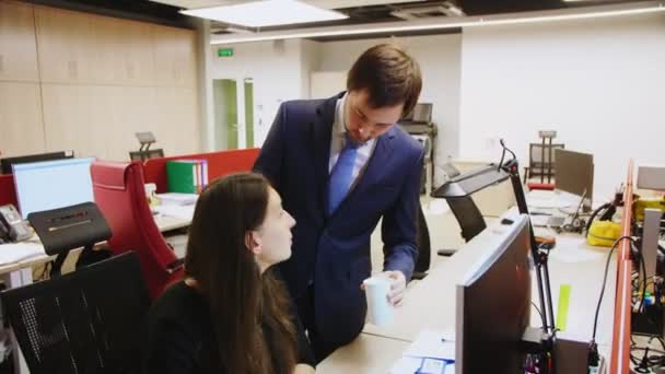 男性は職場でコンピュータを使ったお茶と同僚を扱います — ストック動画