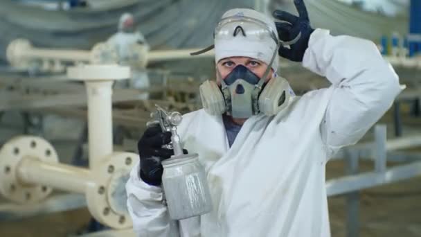 Painter in protective suit takes off respirator in shop — Stock Video