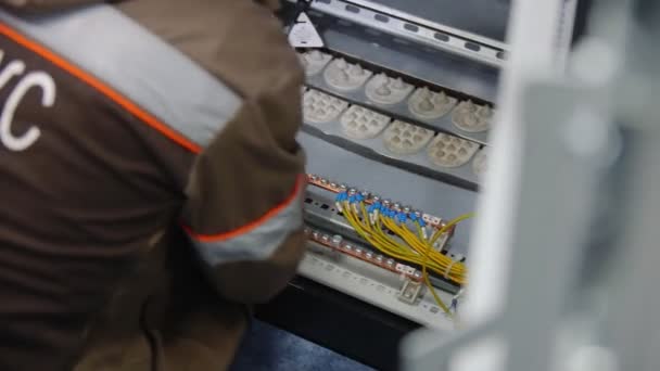 Üniformalı işçi fabrika atölyesinde dağıtım tahtasını tamir ediyor. — Stok video