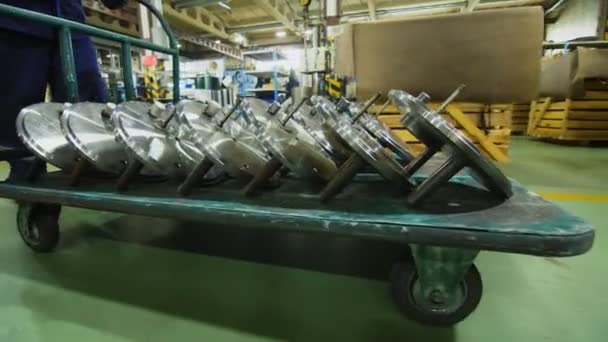 労働者は倉庫でカートの多くのラウンドの詳細を運ぶ — ストック動画