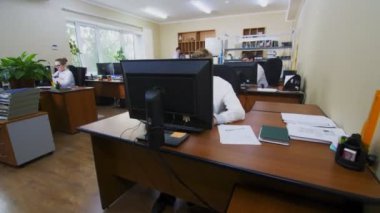 Masalarda ciddi çalışan insanlarla birlikte ofis boyunca hareket